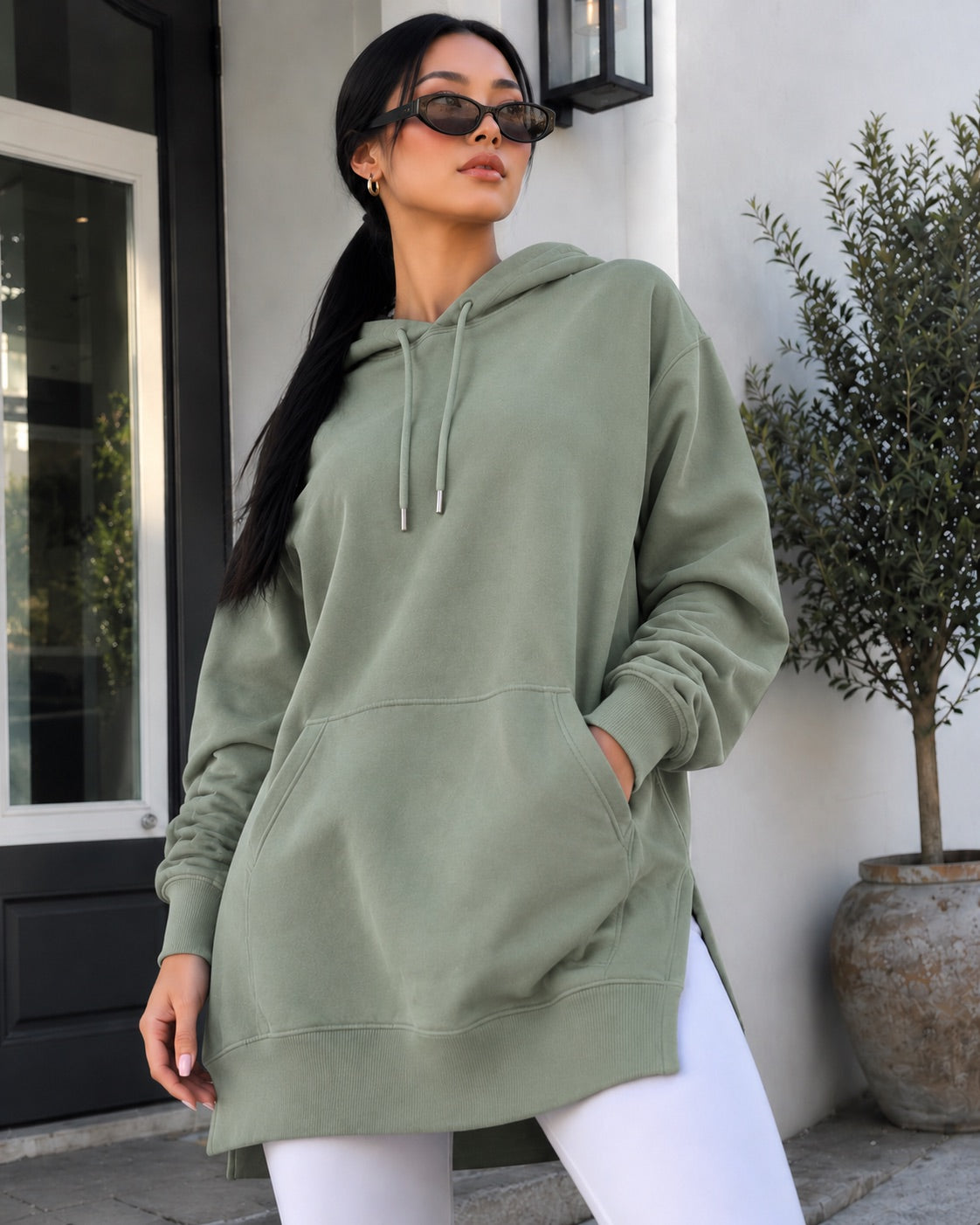 Woman wearing a Warmy hoodie dress over leggings
